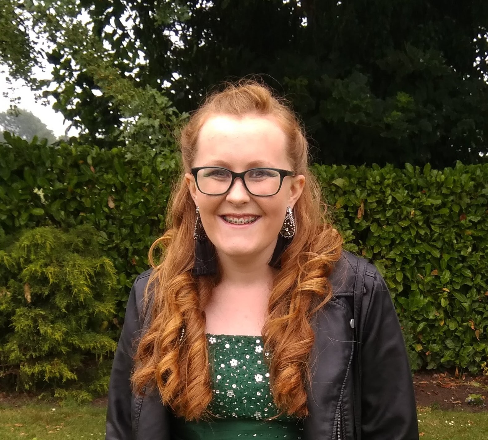 Amy pictured in a green dress and biker jacket 