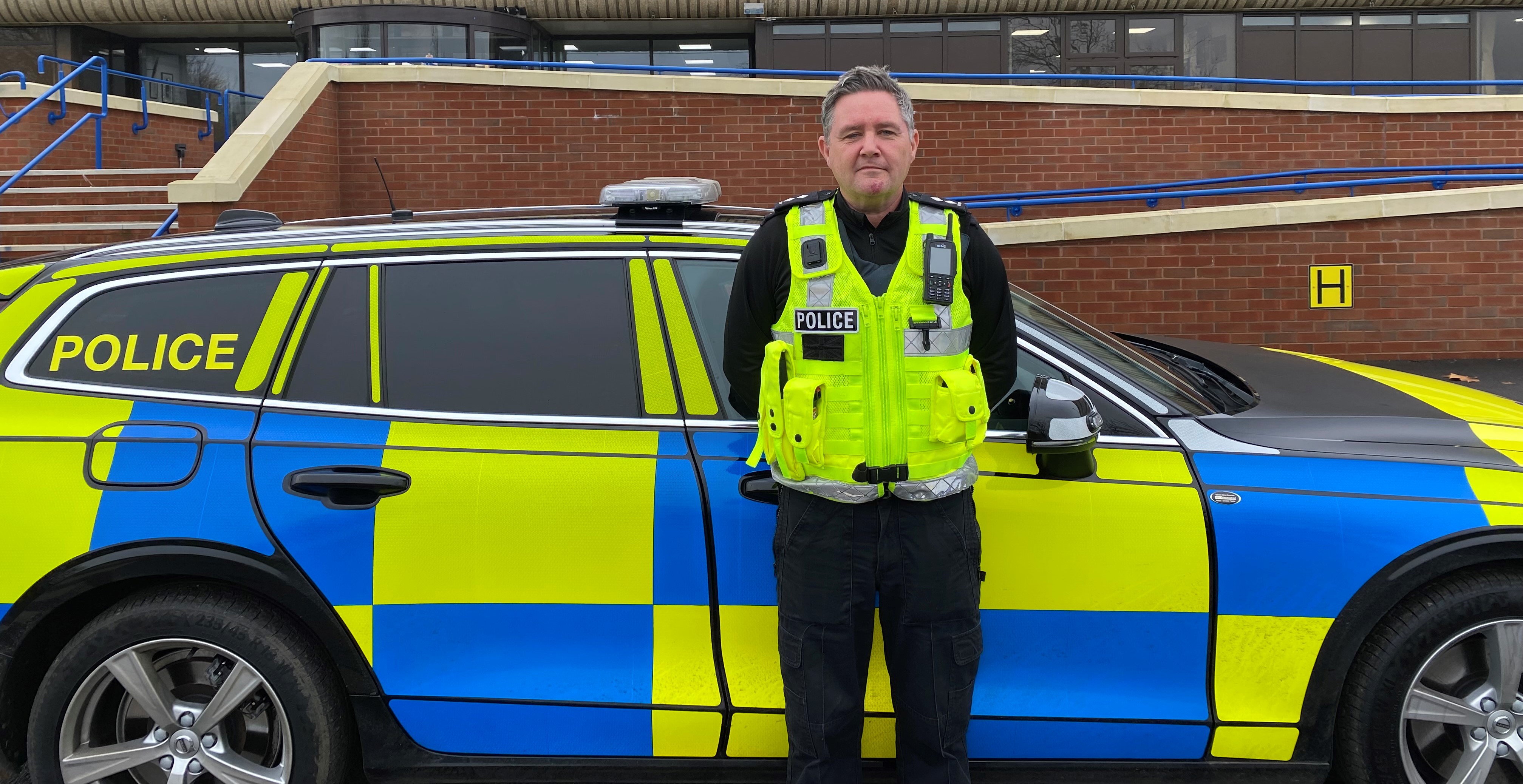Inspector Jason Baxter standing in front of police car