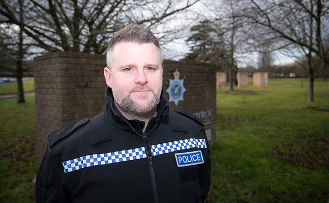 Pc Steve Denniss, in uniform, standing outside Police HQ, looking into the camera