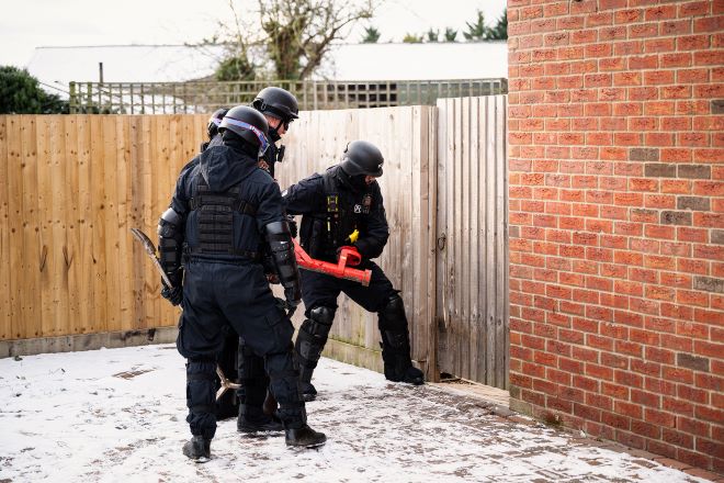 Officers enter a property using 'the big red key'