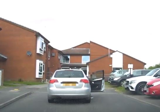 A silver Audi A3 stationary with the drivers side door open.