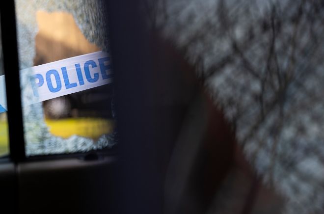Police tape across a broken window, indicating a crime scene.