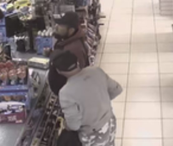Two men at a shop counter. 