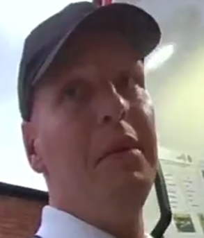 Man wearing a dark coloured cap. 