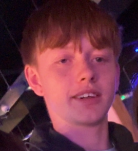 14-year-old Ashton is smiling at the camera.
