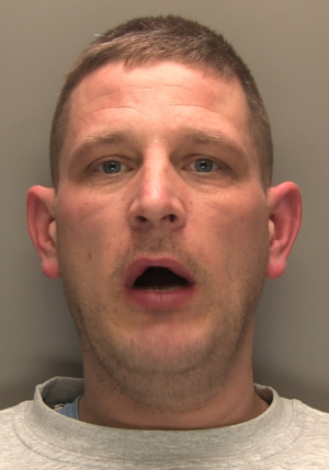 An image of wanted man Peter Gamblin. He is looking straight at the camera and his mouth is open