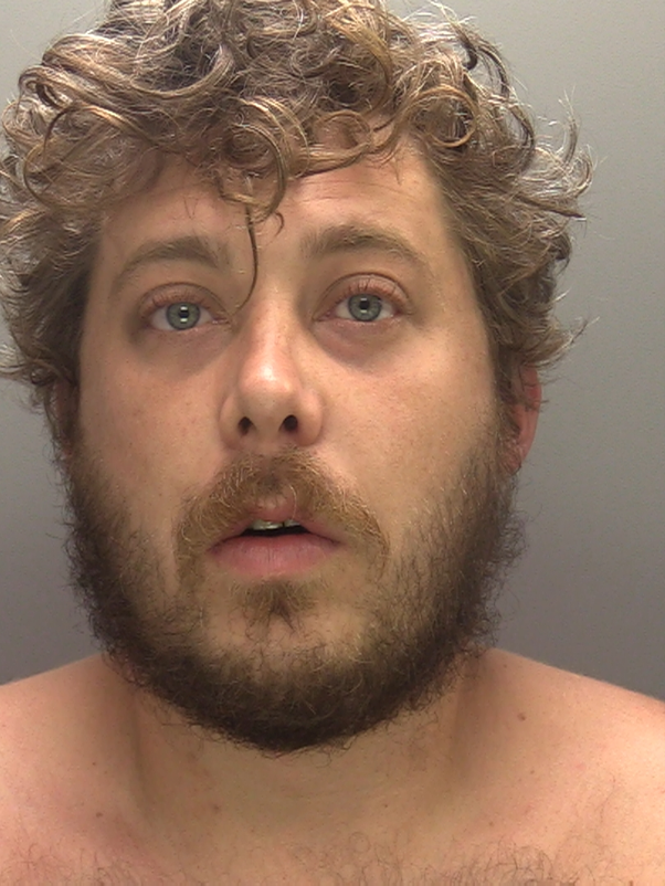 An image of wanted man Charlie Higgs. He has brown hair and brown beer, and is looking at the camera