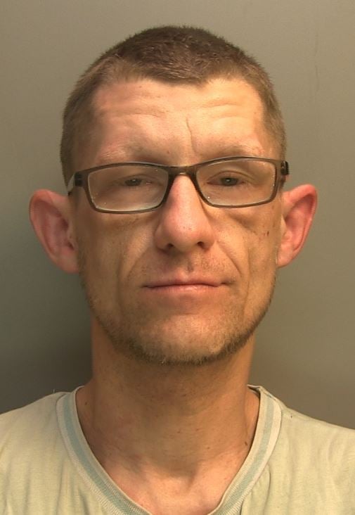 Man with shaven head and glasses