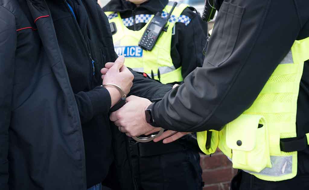 Stock photo close up image of the hands of a police officer arresting a male subject