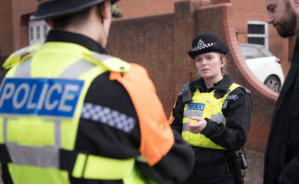 Student officer - with member of public in street (Lucinda Wood (McQuade) - female - talking - neutral - training)